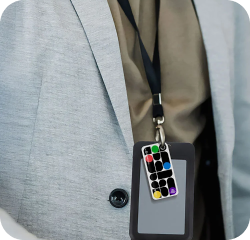 Person in a gray blazer with a black lanyard, with NFC keychain attached to the lanyard