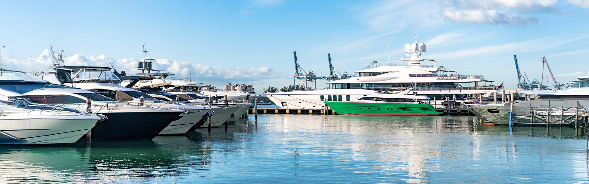 Marina with luxury yachts docked at a dock under a clear blue sky.