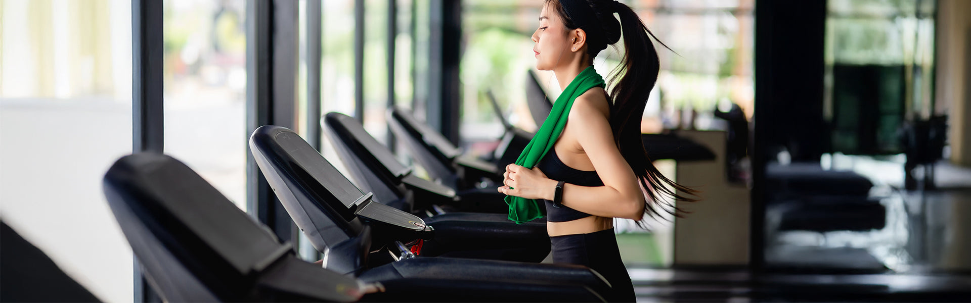 Woman exercising on a treadmill in a gym setting using smart access control